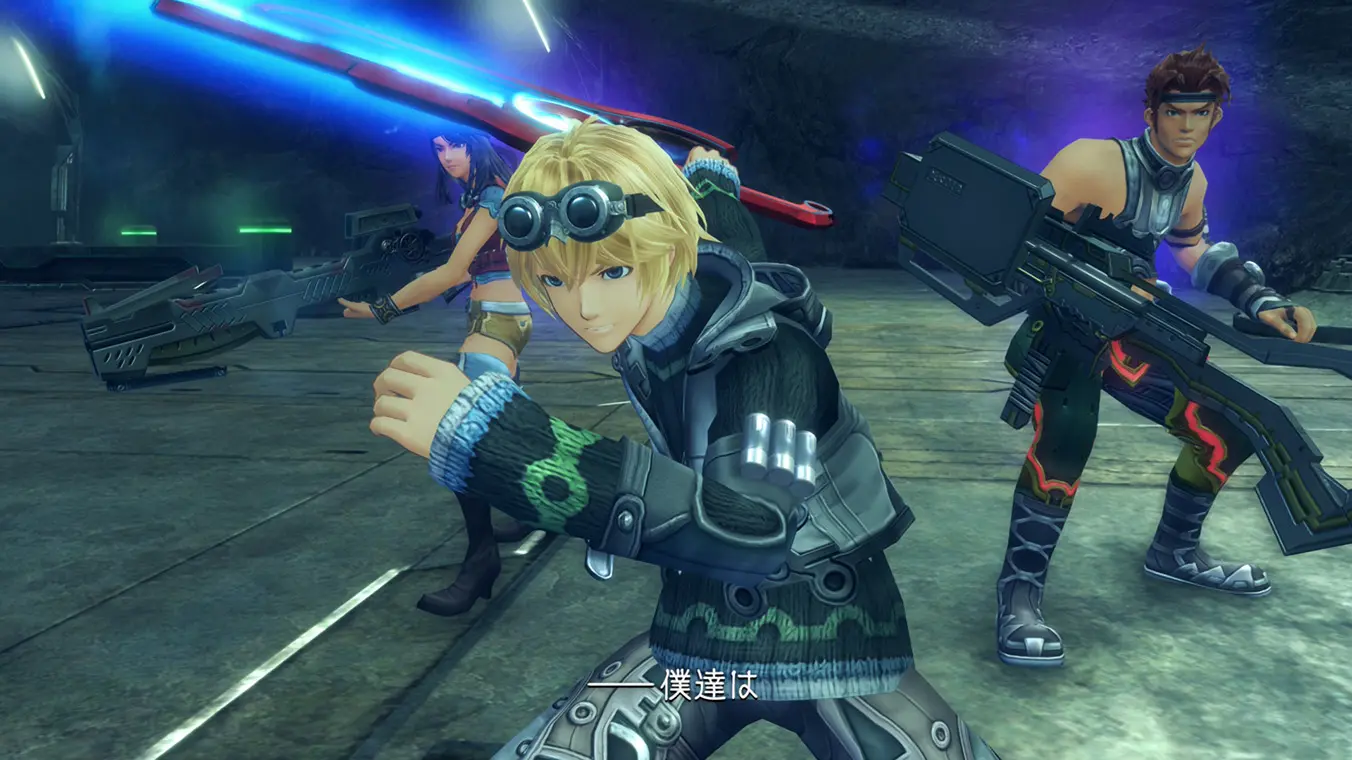 A close-up gameplay cutscene showing the blonde protagonist Shulk in the center, wearing goggles on his head and holding a glowing red sword, the Monado. Two companions stand behind him to his left and right, armed with large guns inside a dark cave setting.